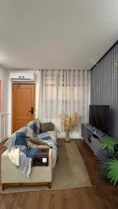 a living room with a bed and a television at Apto aconchegante no centro de Manaus in Manaus
