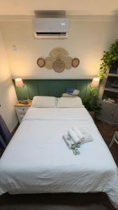 a bedroom with a large white bed with towels on it at Apto aconchegante no centro de Manaus in Manaus
