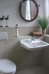 a bathroom with a sink and a toilet and a mirror at Mein Horumersiel in Horumersiel