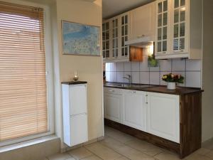 a kitchen with white cabinets and a window at Mein Horumersiel in Horumersiel