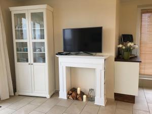a living room with a fireplace with a tv on top at Mein Horumersiel in Horumersiel