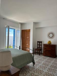ein Schlafzimmer mit einem Bett, einem Fenster und einem Stuhl in der Unterkunft Hotel Tesoriero in Panarea