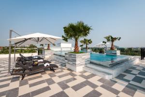 a pool with two lounge chairs and an umbrella at SaLa Tam Coc Hotel & Spa in Ninh Binh