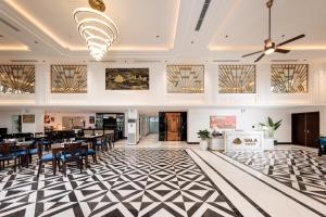 a restaurant with tables and chairs on a black and white floor at SaLa Tam Coc Hotel & Spa in Ninh Binh