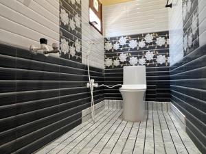 a bathroom with a toilet and black and white stripes at Geetham Homestay in Tiruchirappalli