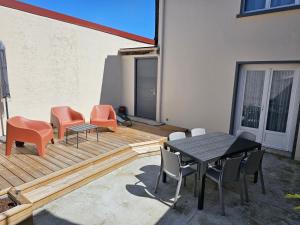 a patio with a table and chairs on a deck at Gîte de la Tour d'horloge in Carvin
