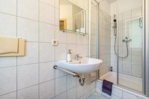 a white bathroom with a sink and a shower at Gästezimmer - Meißen in Meißen +29 photos