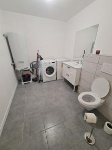 a bathroom with a toilet and a washing machine at Keo Home in Arbent