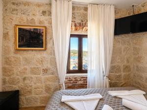 a bedroom with a bed and a window at Boutique Rooms Malo More - Old Town and Parking in Trogir