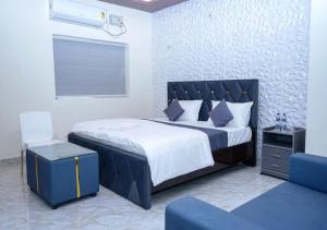 a bedroom with a large bed and a blue chair at Hotel skyline in Visakhapatnam