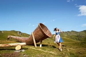 a woman is standing next to a large wooden boat at Anja's Schönblick - Bed & Breakfast in Gerlos
