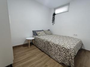 a small bedroom with a bed and a table at Las Nubes Mairena in Mairena del Aljarafe +28 photos