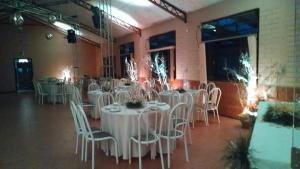 een feestzaal met witte tafels en stoelen bij Pousada Porto Aventuras in Eldorado do Sul 