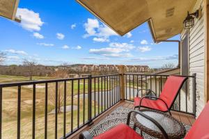a balcony with two chairs and a view of a yard at Hole-in-One Hideaway For 4 in Branson
