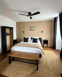 a bedroom with a bed with a ceiling fan at Chambres d'hôtes "Le Petit Cardinal" - proche PuyduFou in Mauléon