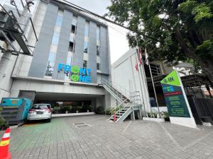 a front entrance of a building with a parking lot at Front One Hotel Gresik in Panggang