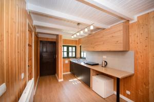 a kitchen with wooden walls and a wooden counter top at Domek na Górce in Lądek-Zdrój +2 photos