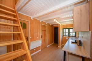 a kitchen with a staircase in a tiny house at Domek na Górce in Lądek-Zdrój