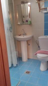 a bathroom with a sink and a toilet at Orly's Villas in Chorefto