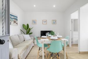 a white living room with a table and chairs at Apartamento Almadraba in Barbate