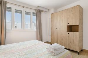 a bedroom with a bed and a large wooden cabinet at Apartamento Almadraba in Barbate