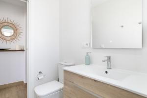a bathroom with a toilet and a sink and a mirror at Apartamento Almadraba in Barbate +19 photos