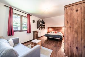 a living room with a couch and a bed at Chalet Tante Emma proche Lac Leman in Vacheresse