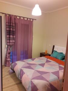 sypialnia z kolorowym łóżkiem i oknem w obiekcie City House Apartment w Salonikach