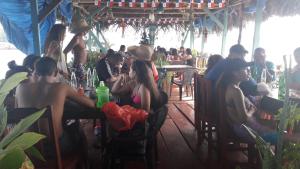 a group of people sitting at tables in a restaurant at Bastimentos Caribean Hotel in Bocas Town