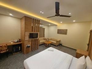 a bedroom with a bed and a living room at Hotel Dolly in Siliguri
