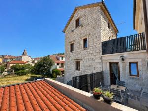 a building with a red roof with plants on it at Boutique Rooms Malo More - Old Town and Parking in Trogir
