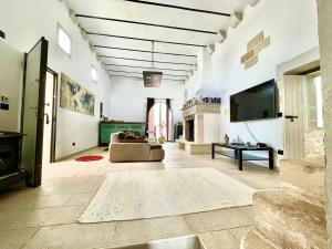 a large living room with a couch and a tv at Antica e luminosa masseria in Lequile
