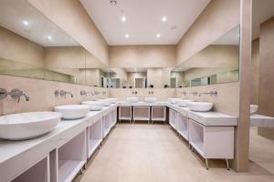 ein großes Badezimmer mit vier Waschbecken und Spiegeln in der Unterkunft Mega Hostel in Sarandë + 187 Fotos