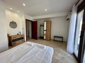a bedroom with a large white bed and a mirror at Lemon Zest in Nea Peramos +18 photos