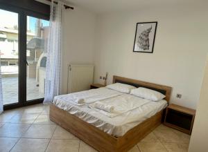 a bedroom with a bed in a room with a window at Lemon Zest in Nea Peramos
