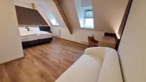 ein Schlafzimmer mit Bett, Schreibtisch und Sofa in der Unterkunft Pawlow History Hotel in Wolkenstein + 33 Fotos