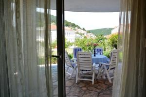 a table and chairs sitting on a patio with a table and chairs at Apartments Mladinić in Pučišća