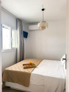 a bedroom with a bed with a tray of fruit on it at Vigla's Tiny House - Steps to the Beach in Mikri Vigla