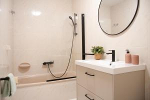 a bathroom with a sink and a shower with a mirror at Mar de Louro in Muros +19 photos