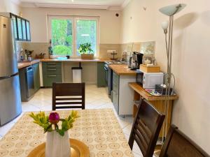 a kitchen with a table with a vase of flowers at Teresa Guest House in Csömör