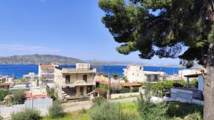 a group of buildings with the ocean in the background at Vens apartment 90m2 at Eantio bay. in Aiándion