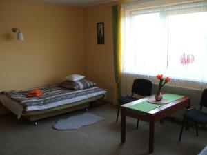 Schlafzimmer mit einem Bett, einem Tisch und einem Fenster in der Unterkunft Apartament Poznań 88A in Posen