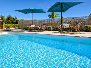 a group of chairs and umbrellas next to a swimming pool at Gite Les Intemporels in Cuisery