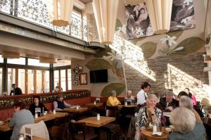 un grupo de personas sentadas en mesas en un restaurante en Cafe Elisabeth, en Mutterstadt