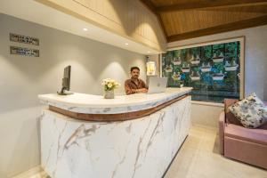 a man sitting at a counter with a laptop at Tripli Hotels Royal Spring in Mussoorie