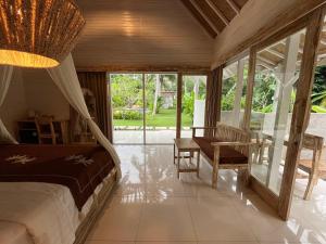 a bedroom with a bed and a desk and a table at Penida West palm cottage in Nusa Penida