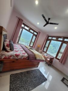 a bedroom with a bed and large windows at Vikas Hotel And Restaurant in Barot 
