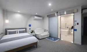 a hotel room with a bed and a bathroom at Sasang Goyohan-hotel in Busan