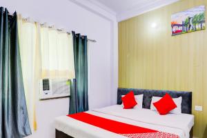 a bedroom with a bed with red pillows at Hotel O Raama in Lucknow +21 photos