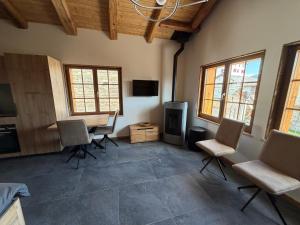 a living room with chairs and a table and a television at Le mazot in Lens